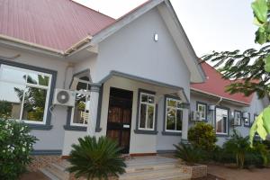 a white house with a red roof at Nyerere Green Lodge in Kwangwazi