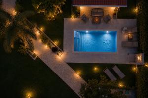 an overhead view of a swimming pool at night at Sea Breeze & Nature villa, with heated pool and garden retreat in Kremasti +72 photos
