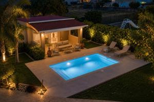an overhead view of a swimming pool in a backyard at night at Sea Breeze & Nature villa, with heated pool and garden retreat in Kremasti