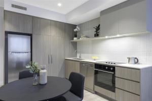 a small kitchen with a table and a stove at Quest Watergardens in Taylors Lakes