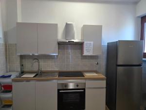 a kitchen with a sink and a refrigerator at Da Silvia ampio appartamento metro Paradiso in Collegno +17 photos