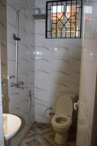 a bathroom with a toilet and a sink and a window at Nyerere Green Lodge in Kwangwazi