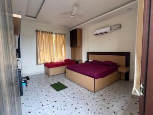 ein Schlafzimmer mit zwei Betten und einem Fenster in der Unterkunft Crystael Hotel in Babarpur