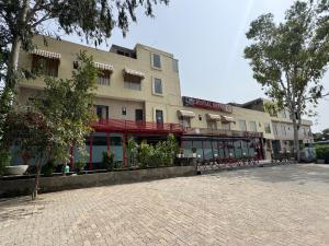 ein großes Gebäude in einer Backsteinstraße mit Bäumen in der Unterkunft Crystael Hotel in Babarpur