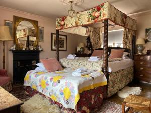 a bedroom with two beds and a canopy bed at Walsingham Bakehouse in Little Walsingham