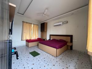 ein Schlafzimmer mit zwei Betten und einem Fenster in der Unterkunft Crystael Hotel in Babarpur