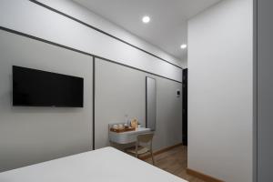 a bedroom with a bed and a tv on a wall at Cove Atman in Jakarta +12 photos