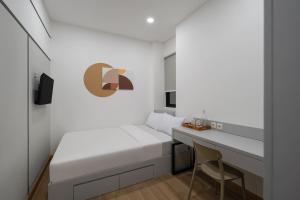 a small bedroom with a bed and a desk at Cove Atman in Jakarta
