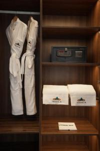 a closet with white robes and a machine and towels at Tshang RI in Thimphu +1 photo