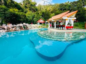 a swimming pool with blue water in front of a house at Apartment On The Mountain in Ban Map Khangkhao