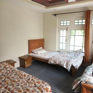 a bedroom with two beds and two windows at Stone Leaf Retreat - Skardu in Skardu +15 photos