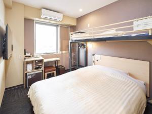 a bedroom with a bed and a desk and bunk beds at Super Hotel Kadoma in Kadoma