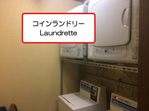 a sign that says laundry in a room with a microwave at Ryokan Meiryu in Nagoya