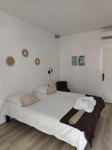 a bedroom with a large white bed with towels on it at Villa lagon bleu in Le Gosier +35 photos