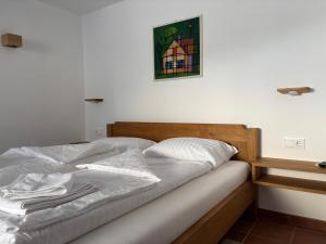 a bed in a bedroom with a picture on the wall at Apartment Erlah in Rateče