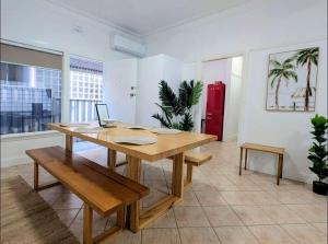 a dining room with a wooden table and benches at Cozy Loft Beach House in Wollongong