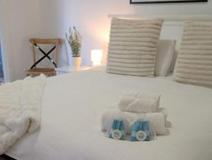 a white bed with towels and a pair of baby blocks on it at Cozy Loft Beach House in Wollongong