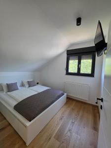 a white bedroom with a bed and a window at Luni Stay - Jacuzzi, Sauna & Nature Escape in Jastrebarsko +15 photos