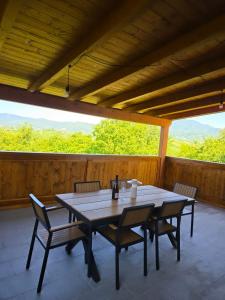 a table and chairs on a porch with a view at Luni Stay - Jacuzzi, Sauna & Nature Escape in Jastrebarsko