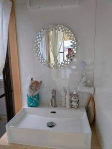 a bathroom with a white sink and a mirror at Kumanokodo KURA in Shingū