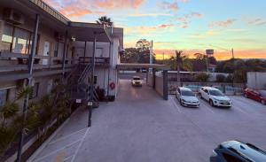 a parking lot with cars parked outside of a building at Nowra Motor Inn in Nowra