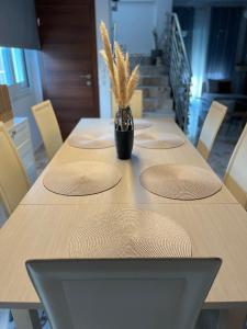 a table with four chairs and a vase of wheat at Giouli's Maison in Eretria