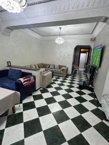 a living room with a couch and a checkered floor at Martil in Martil