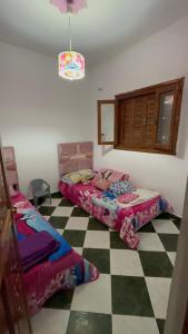a bedroom with two beds and a checkered floor at Martil in Martil