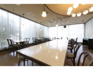 Habitación grande con mesa grande y sillas. en Business Hotel Okada Toyohashi en Toyohashi
