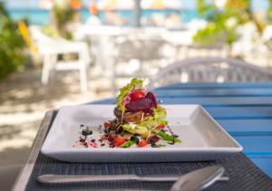 a white plate with a salad on a table at Kaani Haven Beach in Ukulhas +35 photos