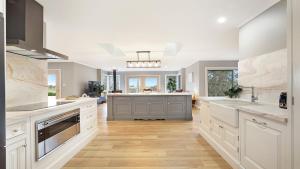 a large kitchen with white cabinets and a large island at Curra Nardie Ranch in Sutton Forest