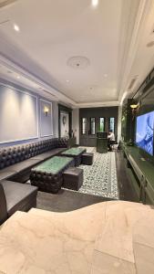 a movie room with a couch and a flat screen tv at Brilliant Jade Suites in Hanoi