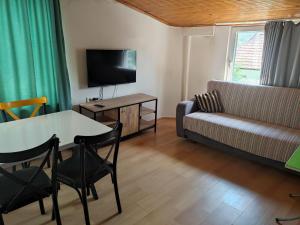 a living room with a table and a couch at Garden Prizma Apart in Kemer