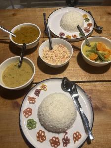 a table with plates of rice and bowls of soup at Kora Beach House & Restaurant Cafe in Ampara
