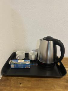 a tea kettle and two cups on a tray at Kora Beach House & Restaurant Cafe in Ampara