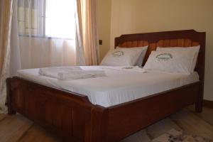 a bed with white sheets and white pillows on it at Nyerere Green Lodge in Kwangwazi +7 photos