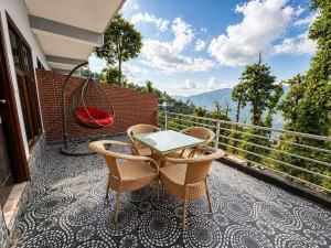 a patio with two chairs and a table on a balcony at Grand Vista Retriet- A luxury Mountain View Property In Mussoorie By Lilly in Mussoorie