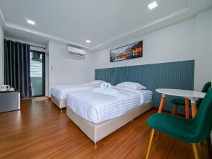 a bedroom with a bed and a table and a chair at ยูพี โคซี่ in Nakhon Nayok +4 photos