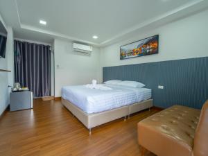 a bedroom with a bed and a tv on the wall at ยูพี โคซี่ in Nakhon Nayok