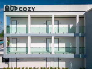 a large white building with a sign on it at ยูพี โคซี่ in Nakhon Nayok