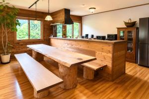 a kitchen with a wooden table and benches at 実と來-mitoki in Takayama