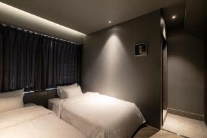 a bedroom with two beds and a window at ONUA Gwangalli in Busan