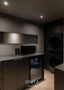 a kitchen with a microwave oven and a stove at ONUA Gwangalli in Busan