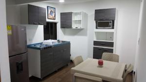 a small kitchen with a table and a refrigerator at Beach Paradise Apartments in San Andrés