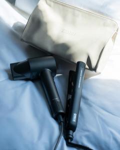 a flashlight laying on a bed next to a bag at ONUA Gwangalli in Busan