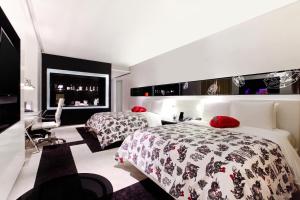 a hotel room with two beds and a desk at W Bangkok Hotel in Bangkok