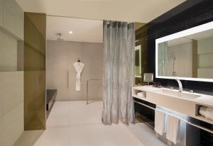 a bathroom with a sink and a mirror at W Bangkok Hotel in Bangkok