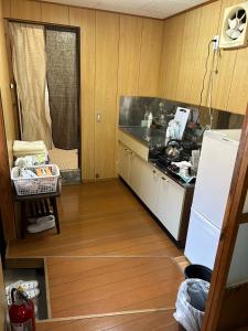 a small kitchen with a counter and a refrigerator at ゲストハウスぬっく in Tanabe