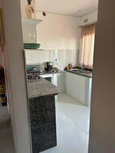 a kitchen with white cabinets and granite counter tops at Serenity Haven in Chongwe +5 photos