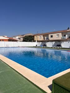 a swimming pool with blue water in front of a building at Apartamento Carmen in Macastre